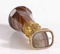 A gilt metal and banded brown agate desk seal, English, circa 1880, the rounded pommel above an