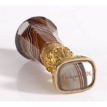 A gilt metal and banded brown agate desk seal, English, circa 1880, the rounded pommel above an