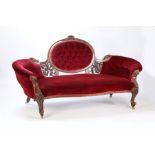 A Victorian Walnut and upholstered settee, having a balloon buttoned back and having a pierced