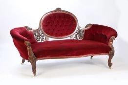 A Victorian Walnut and upholstered settee, having a balloon buttoned back and having a pierced