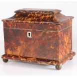 A 19th century tortoiseshell tea caddy, having a angled lid opening to reveal two lidded