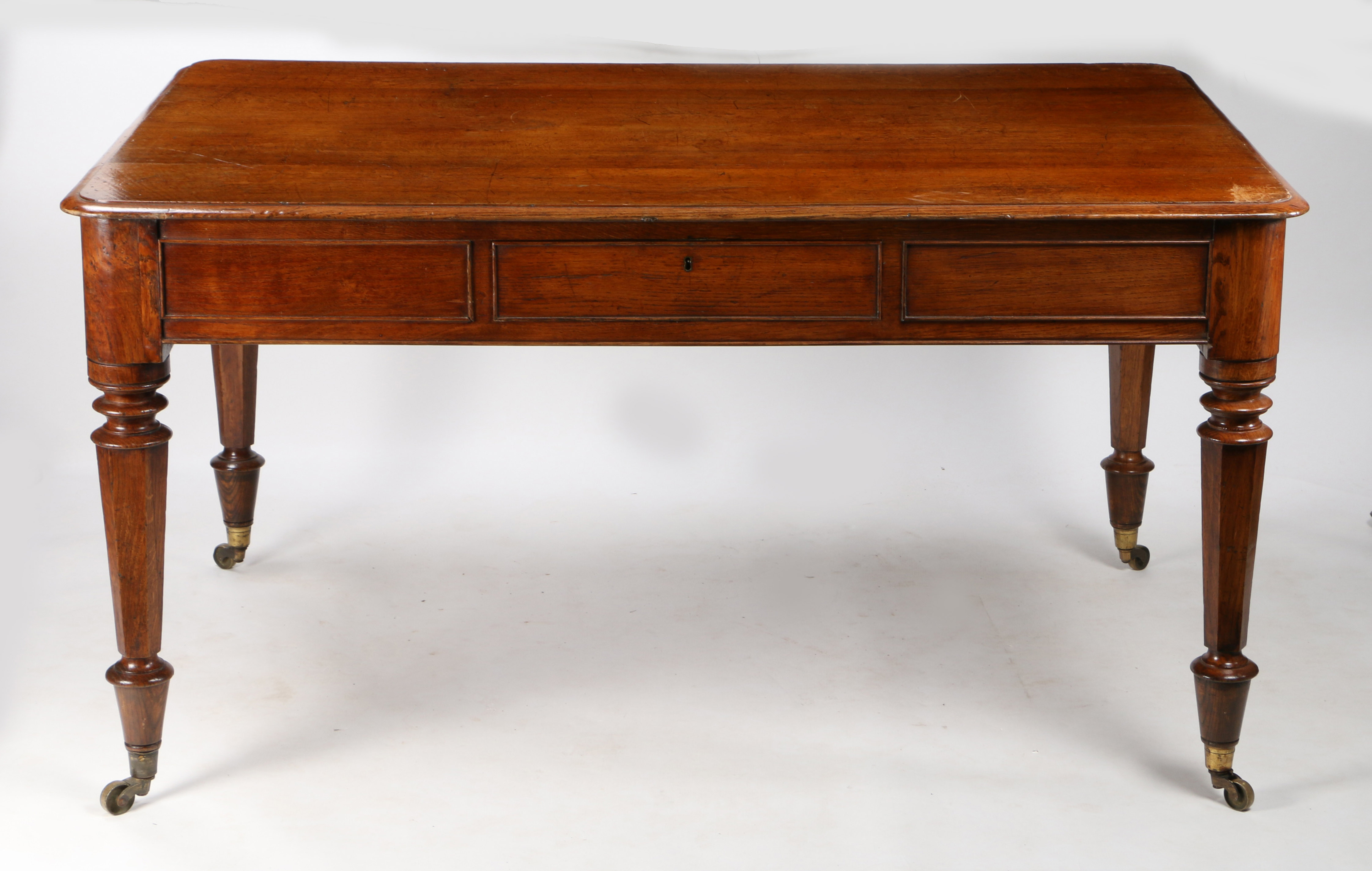 A 19th century oak library table, the rectangular top with chamfered corners above two drawers