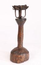 A wrought-iron and timber oil-type lamp Having a cruise-lamp type reservoir, on a primitive pillar