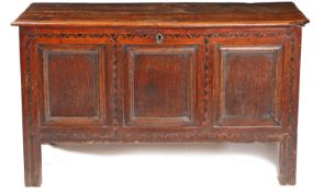 A 17th century oak and inlaid coffer, having a two plank top above a geometric inlaid frieze and a