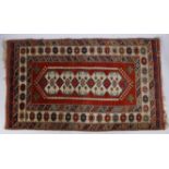 A Caucasian Rug, having a red ground set with central star guls and a hooked design together with