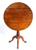 A George II solid yew tripod occasional table, circa 1750 Having a circular four-plank tilt-action