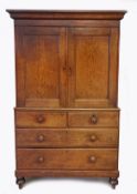 A Mid 19th century oak linen press, having a out swept cornice above a pair of cupboard doors