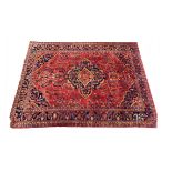 A Hamadan Carpet, the blood red field of flowering plants centred by an indigo medallion framed by