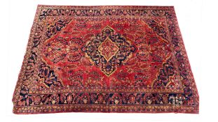 A Hamadan Carpet, the blood red field of flowering plants centred by an indigo medallion framed by