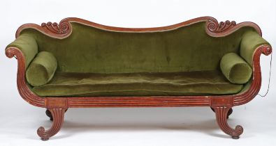 A Regency mahogany and upholstered settee, having a wavy cresting rail above scroll reeded arms