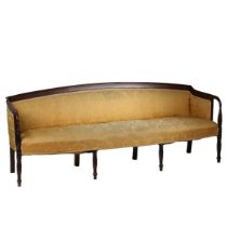 A Regency mahogany and upholstered three seater settee, having a arched back raised on down swept