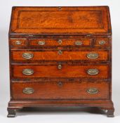A George III oak and inlaid bureau, having a inlaid and cross banded sloping fall opening fall