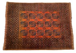 An Afghan Turkmen Carpet the deep terracotta field with three columns of ‘elephant foot’ guls