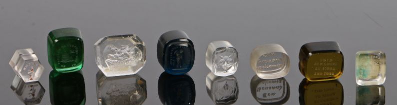 Eight 19th century glass intaglio seals, to include examples in the form of figures and sayings