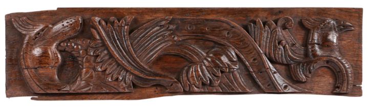 An unusual 16th century carved oak panel Boldly carved with foliage, the head of a cockatrice, and