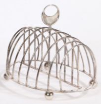 A George III silver toast rack, London 1811, maker Samuel Hennell, the pierced crescent form