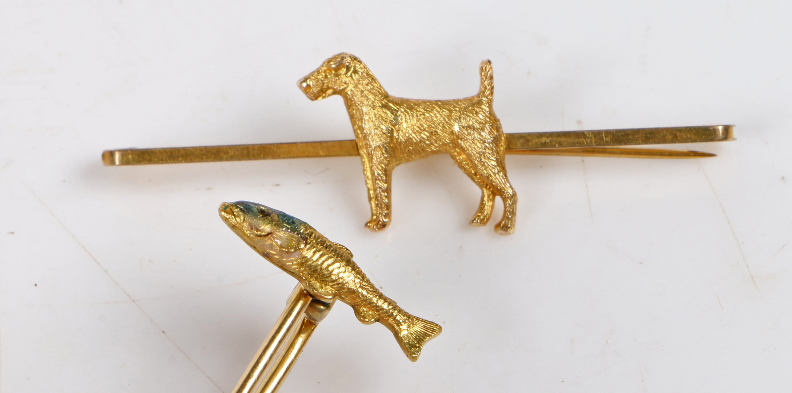 A 9 carat gold bar brooch with central depiction of a terrier, 50.5mm wide, 2.3g, together with a