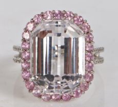 An 18 carat gold kunzite and pink sapphire ring, the central facet cut kunzite surrounded by a