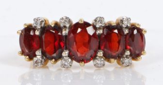 An 18 carat gold, garnet and diamond ring, the head set with five graduated oval facet cut garnets