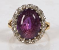 An 18 carat gold amethyst and diamond ring, centred with an oval cut amethyst surrounded by