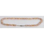 A single strand pearl necklace, the clasp with central diamond and flanked by diamond chips, 43cm