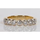 An 18 carat gold and diamond ring, set with seven round brilliant cut diamonds, ring size K 1/2, 5.