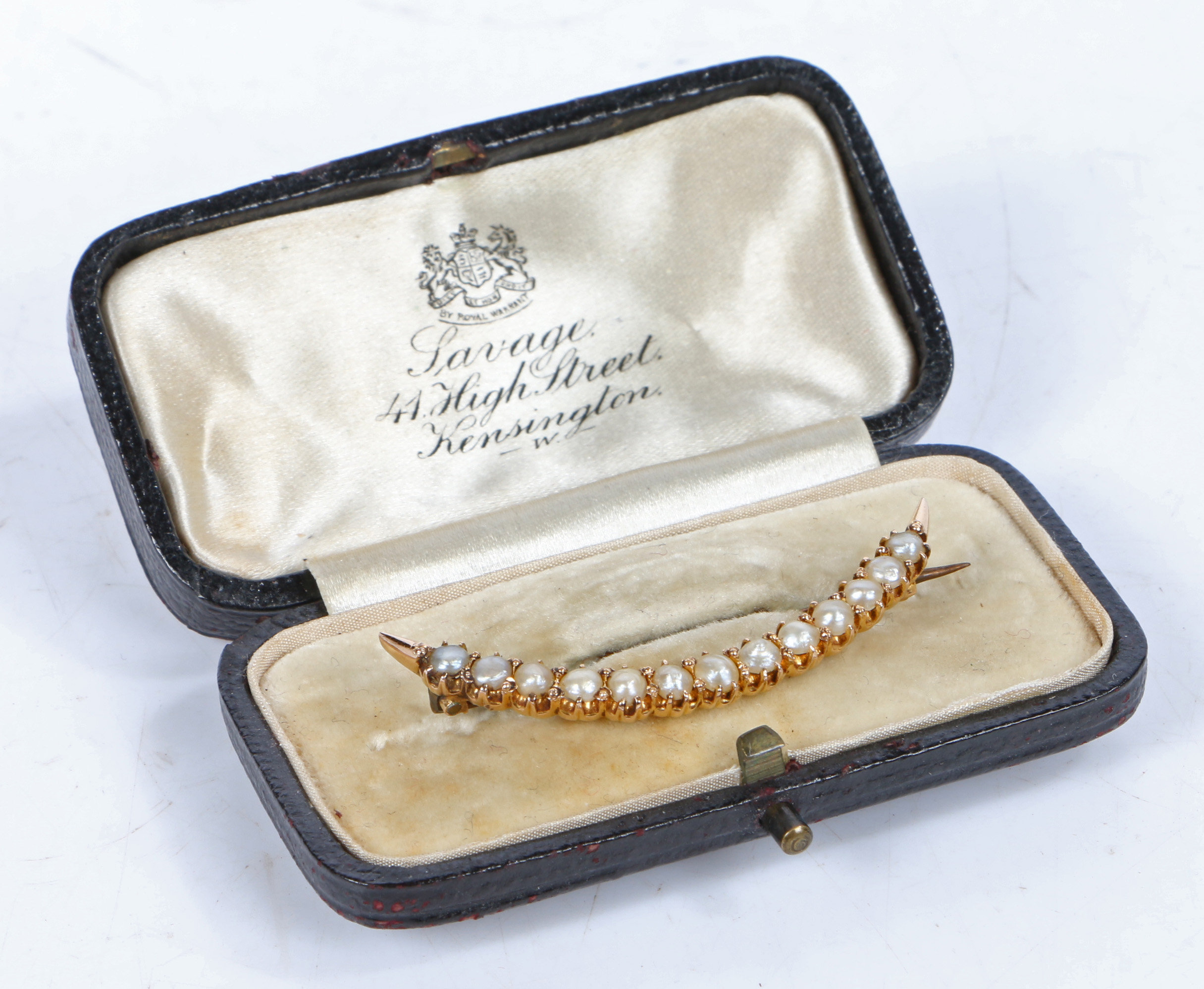 A yellow metal and pearl brooch, of crescent form set with thirteen pearls, 44mm wide