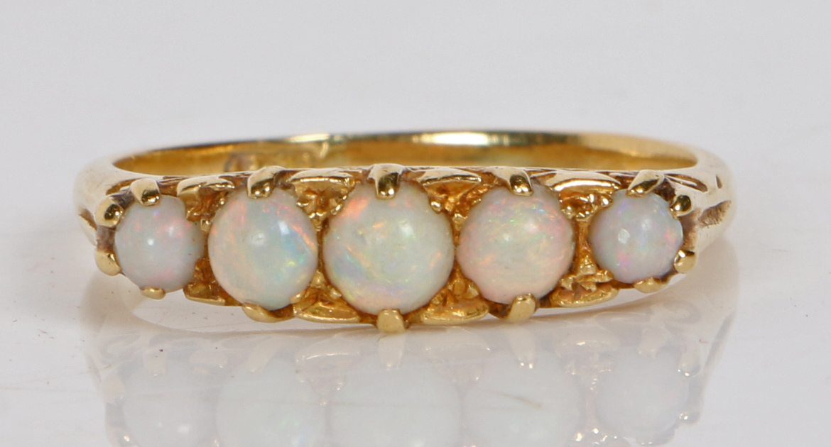 An 18 carat gold and opal ring, the head set with five graduated circular opals, ring size Q, 3.7g