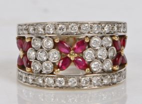 An 18 carat gold, ruby and diamond ring, the pierced stylised foliate head set with twelve oval