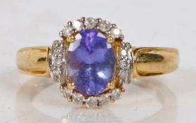 An 18 carat gold tanzanite and diamond ring, the central oval facet cut tanzanite surrounded by a