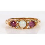 An 18 carat gold, opal, diamond and ruby ring, the central round opal flanked by four diamond