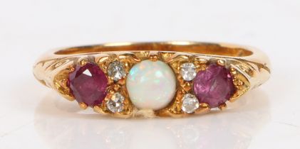 An 18 carat gold, opal, diamond and ruby ring, the central round opal flanked by four diamond