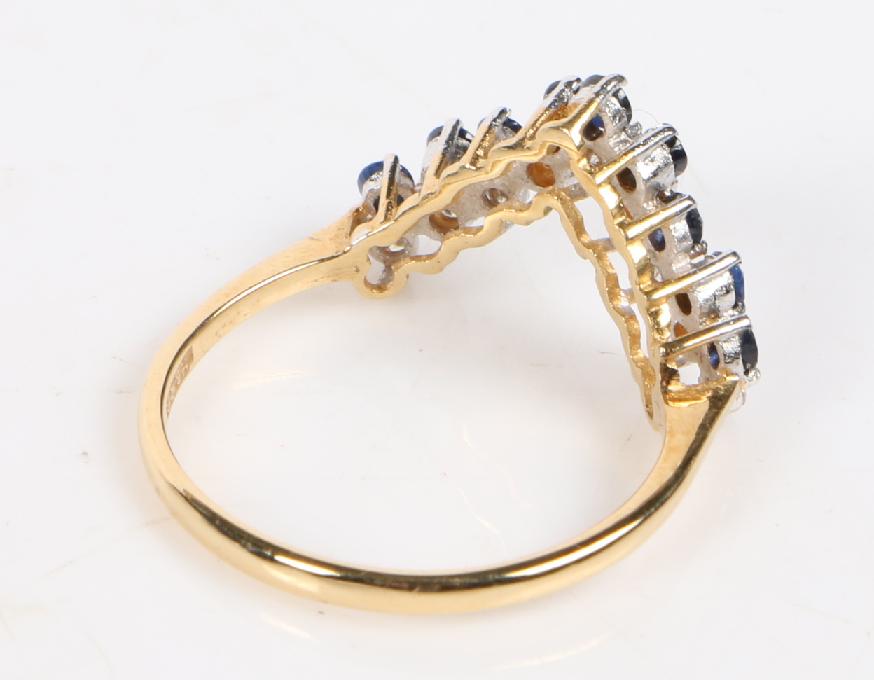An 18 carat gold, sapphire and diamond ring, the V shaped head set with nine round cut sapphires and - Image 2 of 2