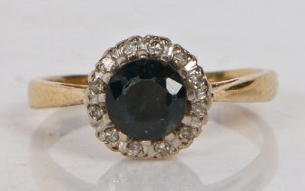 An 18 carat gold, sapphire and diamond ring, the central circular facet cut sapphire surrounded by a