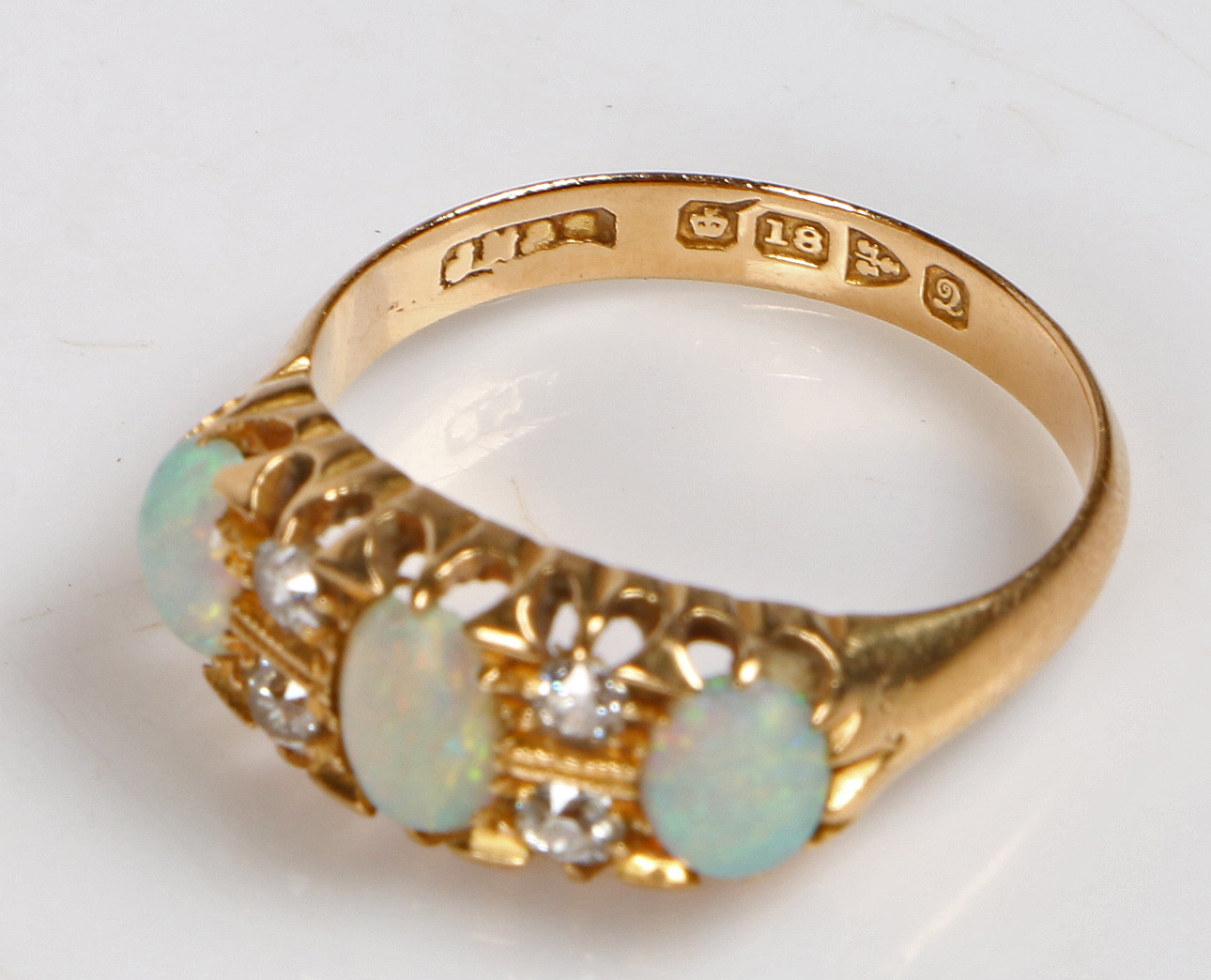 An 18 carat gold, opal and diamond ring, the head set with three oval opals interspersed by four - Bild 3 aus 3