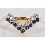 An 18 carat gold, sapphire and diamond ring, the V shaped head set with nine round cut sapphires and