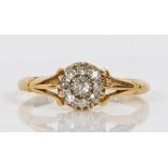 An 18 carat gold ring set with a central diamond surrounded by a band of eight diamond chips, ring