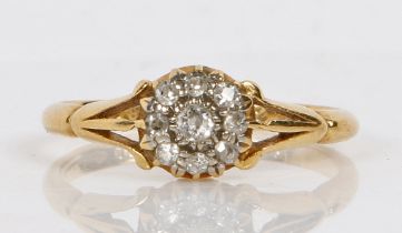 An 18 carat gold ring set with a central diamond surrounded by a band of eight diamond chips, ring