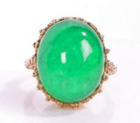 An impressive jade and yellow metal ring, the head set with a large claw mounted cabochon cut jade