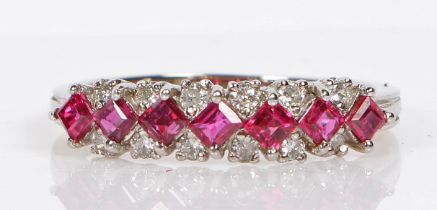 An 18 carat white gold, ruby and diamond ring, with a central band of seven square cut rubies