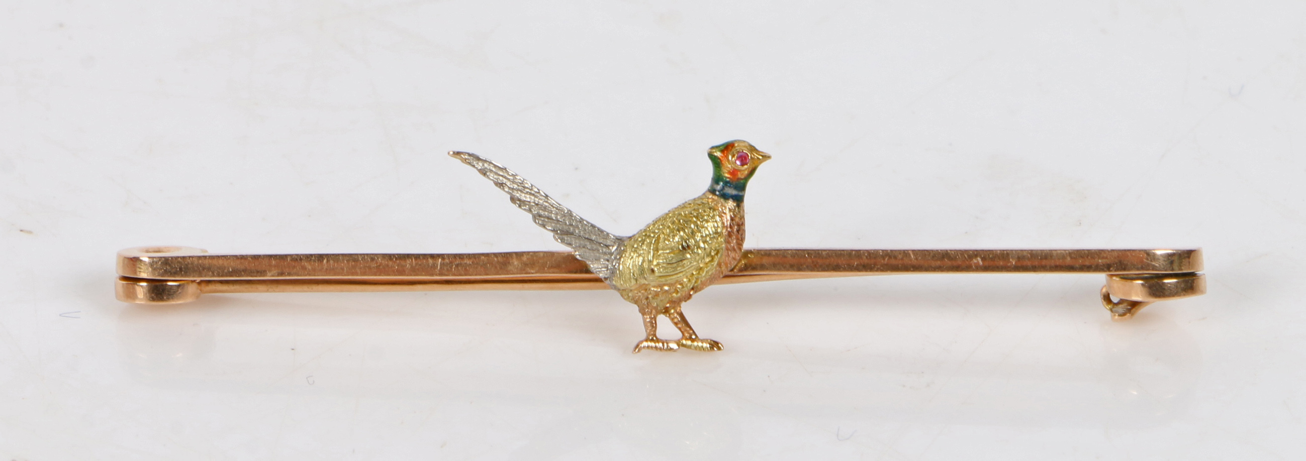 A 15 carat gold bar brooch with central depiction of a cock pheasant, decorated with enamel and with