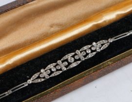 An Art Deco diamond set bracelet, the bracelet with stylised flower head and oval panels set with
