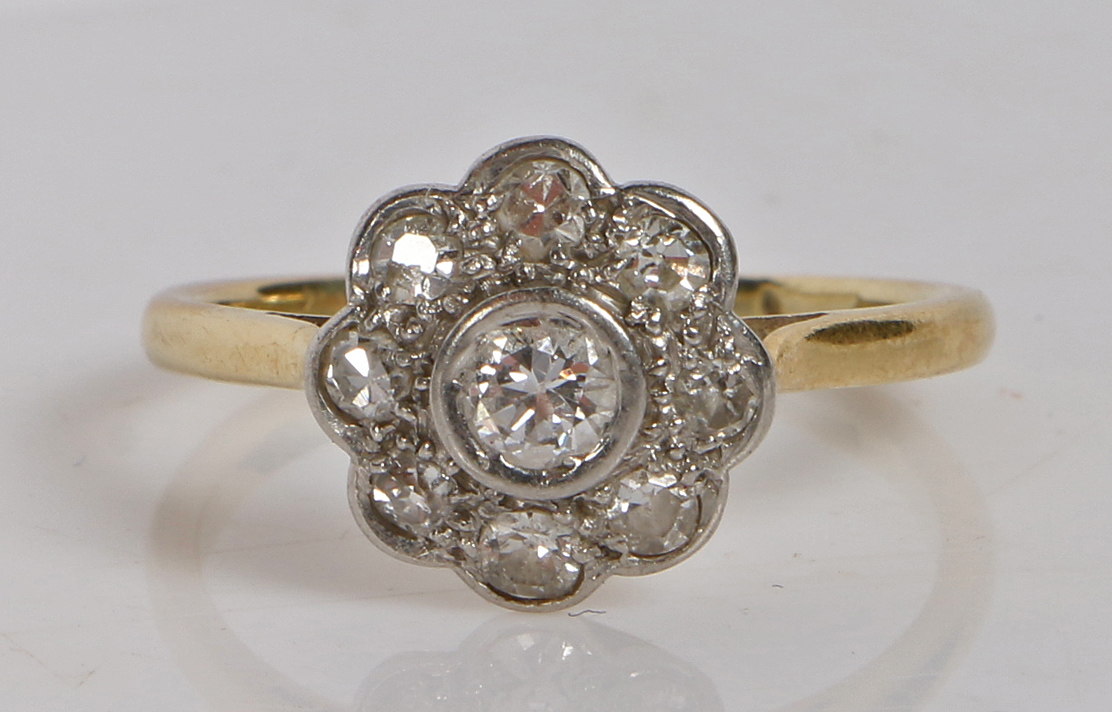 A yellow metal, platinum and diamond ring, the head set with a central round diamond surrounded by a