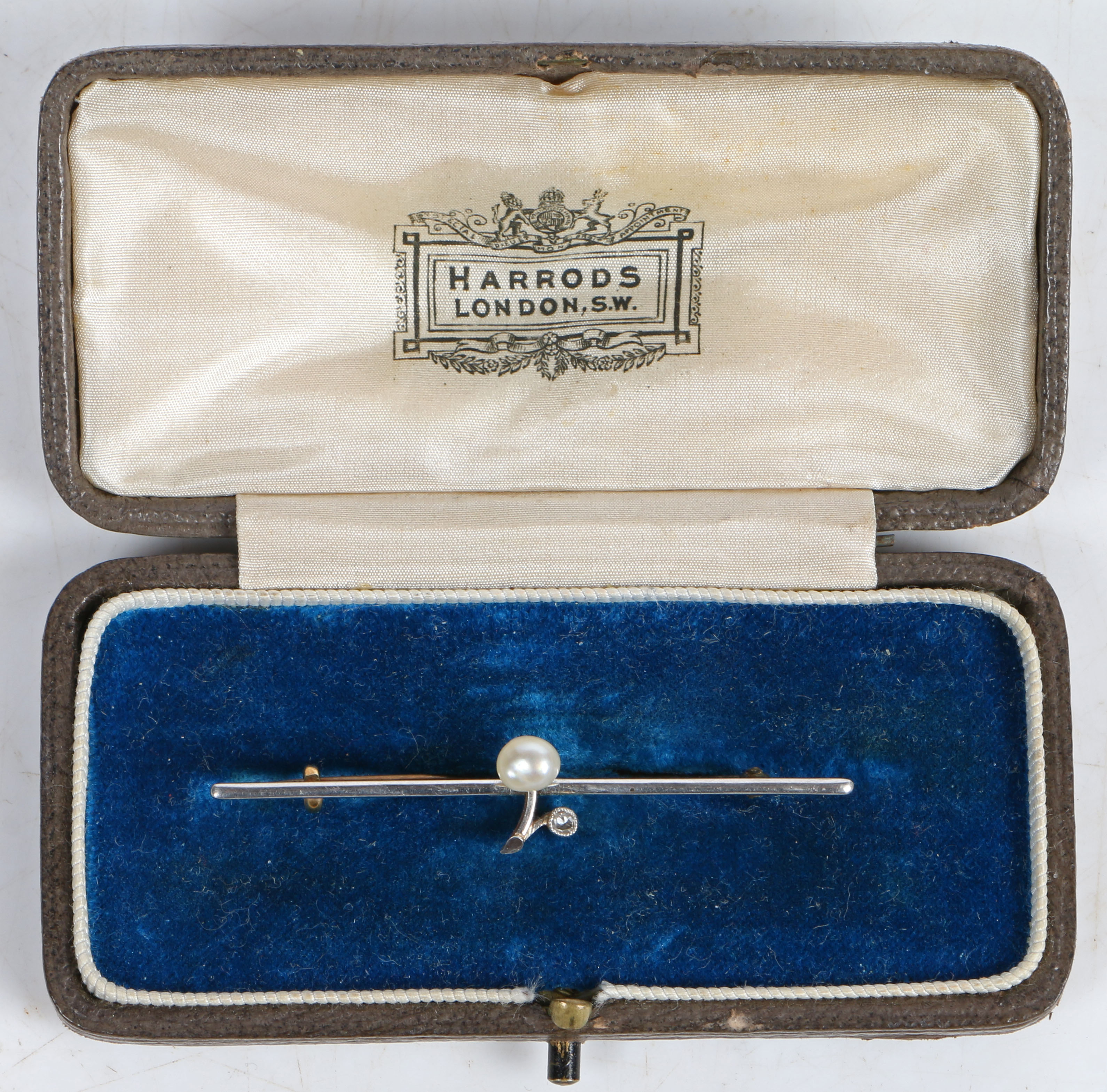 An Edwardian yellow and white metal bar brooch, the bar with central stylised branch set with a