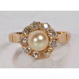 A yellow metal pearl and diamond ring, with central pearl surrounded by nine diamonds, the pearl