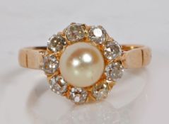 A yellow metal pearl and diamond ring, with central pearl surrounded by nine diamonds, the pearl