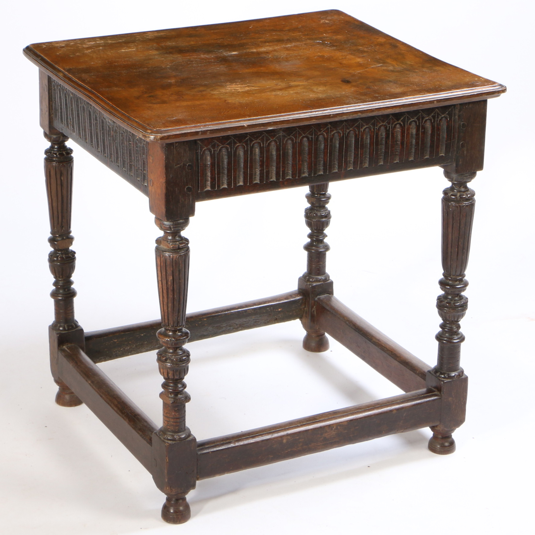 An oak side table, the square top above carved and turned legs united by stretchers, early elements,