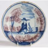 An 18th Century Delft plate, the central field with depiction of a seated gentleman, possibly a