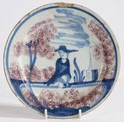 An 18th Century Delft plate, the central field with depiction of a seated gentleman, possibly a