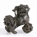 A Chinese bronze dog of fo, modelled in a standing position with front right paw raised on a pierced